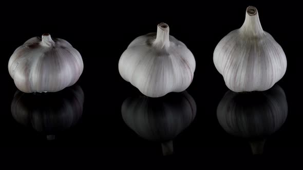 Closeup Organic Three Heads of Garlic Shown From Different Angles Which Are Lying on a Table