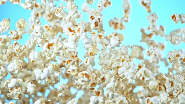 Super Slow Motion Shot of Popcorn on Blue Background After Being Exploded at 1000Fps