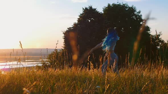 Woman with Long Braids Slowly Dancing on Sunset Meadow