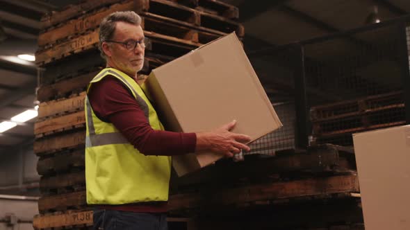 Worker arranging box in warehouse