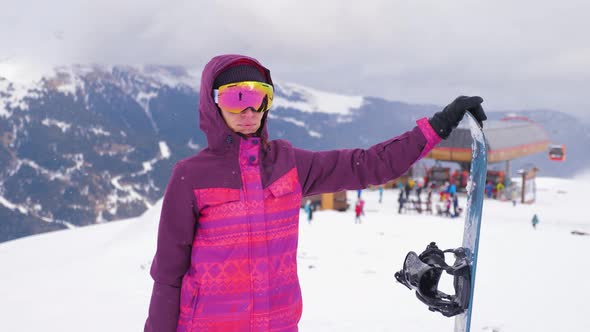 Girl Snowboarder with Snowboard on Mountain Top on Ski Resort. Winter Sports and Winter Vacation