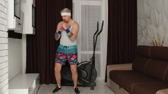 Sportsman Stylish Fat Guy in Funny Clothes Making Boxing Exercises with Dumbbells in Place at Home