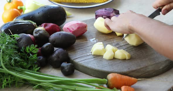 A woman is cooking vegetables in a kitchen, cut colors  potatoes