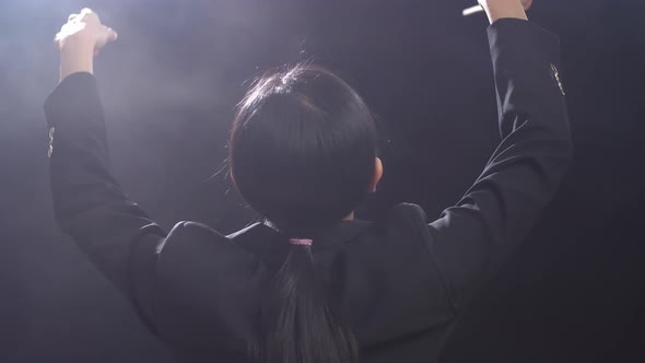 Close Up Of Back View Asian Conductor Woman Holding A Baton Closing Her Eyes And Showing Gesture