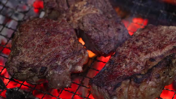 Searing ribeye steaks on BBQ flame grill