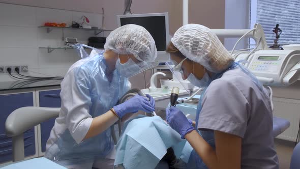 General Plan Two Female Dentists Perform The Operation Of The Patient's Teeth, Modern Dentistry