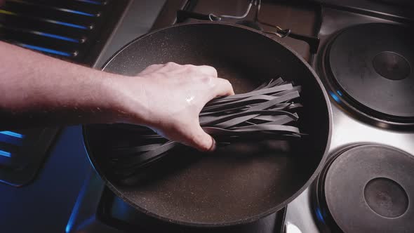 Cooking Squid Ink Noodles With Vegetables And Tomato Puree In A Pan. Weight Loss Pasta Recipe. high