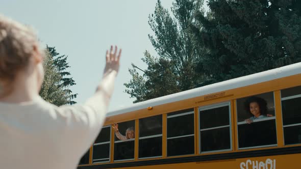 Loving Mother Waving Son Sitting Bus