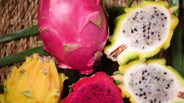 Yellow and Pink Pitahaya on Palm Branch, Rotating Background. Top View. Citrus Fruits. Vegan and Raw