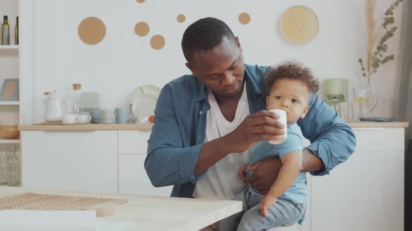 Dad Giving Water to Little Child