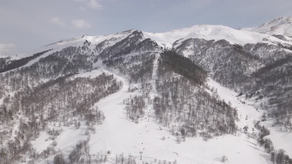 Flying over rope-way with gondolas at mountain resort Crystal Park in Bakuriani. Snowy winter day.