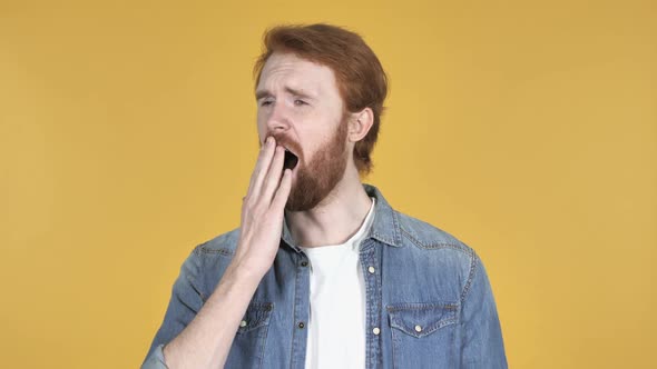 Redhead Man Yawning and Stretching BodyIsolated on Yellow Background