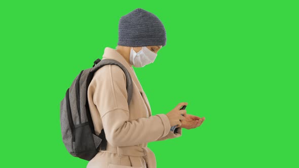 Blonde Woman in Medical Mask During Quarantine Period Using Sanitizer on a Green Screen, Chroma Key