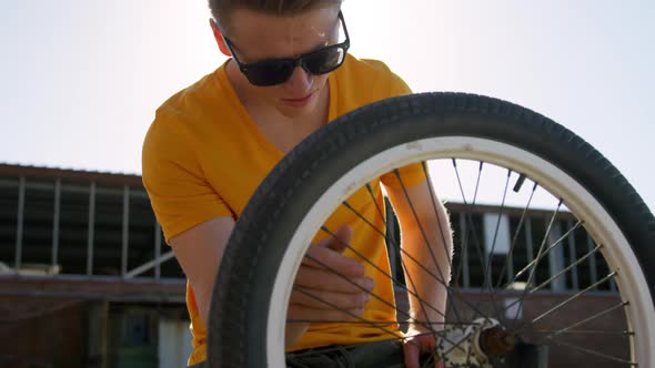 BMX rider repairing wheel