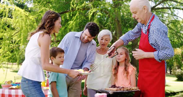 Multi-generation family having their lunch in the park