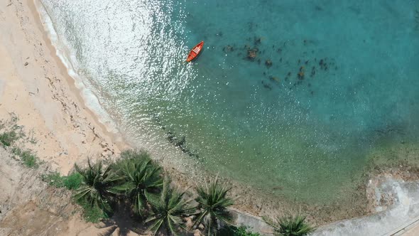 Aerial coral bay and beach view with red kayak and people swimming