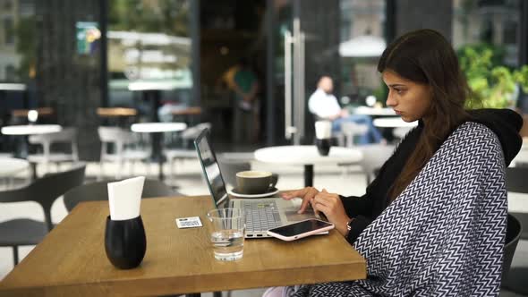 Female Student Using Netbook While Sitting in Cafe