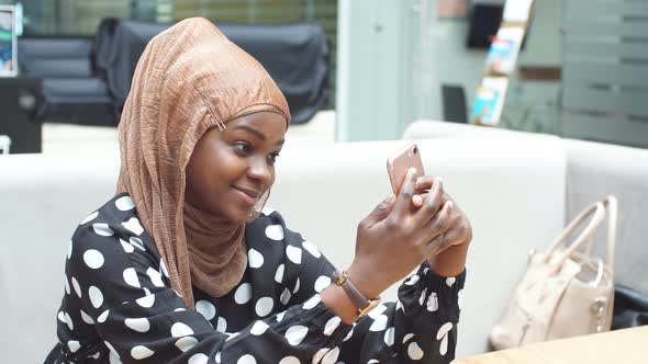 Smartphone in the Hands of a Beautiful Arabian Woman Wearing a Hijab