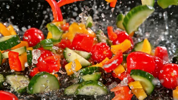 Super Slow Motion Shot of Colorful Vegetables Falling Into Water on Black Background at 1000Fps