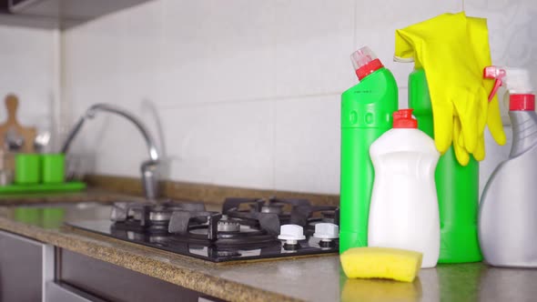 Rotate camera from kitchen focus to bottles of cleaning and detergent.