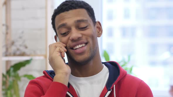 AfroAmerican Man Busy Talking on Smartphone with Customer