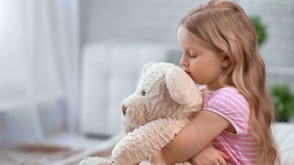 Dramatic Lonely Kid Embrace Toy Bear Feeling Sadness at Cosiness Home