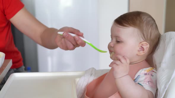 Woman feeds a little baby girl