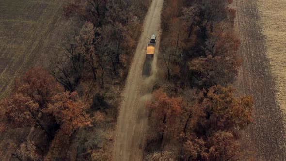 Aerial Drone View Flight Over Blue Tractor With Trailer Filled Yellow Corn Grain