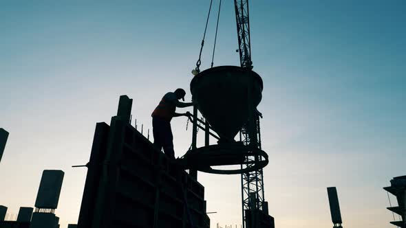 Male Worker Is Operating a Barrel with Concrete on the Roof alt