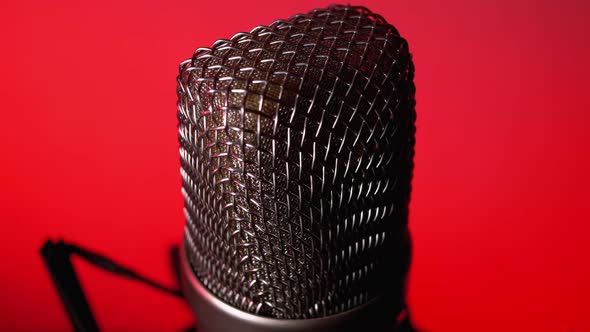 Studio Condenser Microphone Rotates on Red Background.