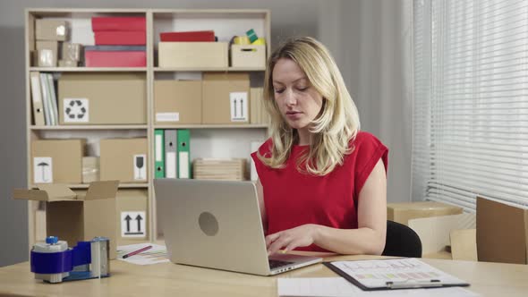 Female Manager Working on Laptop at Post Office and Typing on Keyboard