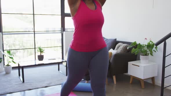 African american female plus size standing on exercise mat working out