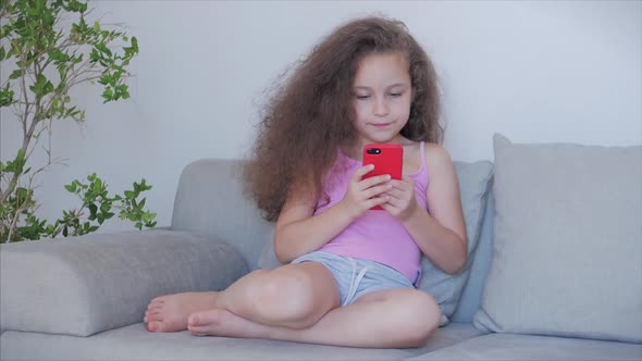 Curious Cute Girl Preschool Child Using a Digital Tablet Technology Device Looks telephone