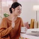 Young modern Asian woman works from home with laptop computer in living room. - VideoHive Item for Sale