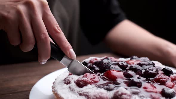 Woman is Cutting a Cake with Jelly Fresh Berries