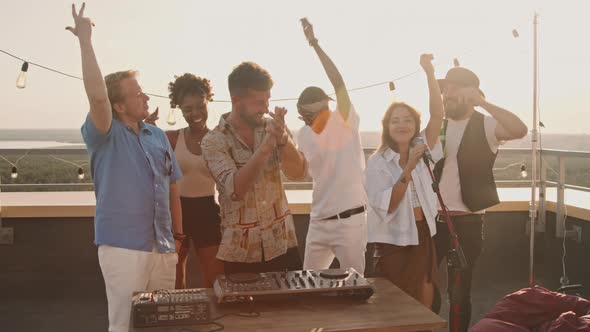 Young People Partying on Rooftop Terrace on Summer Evening