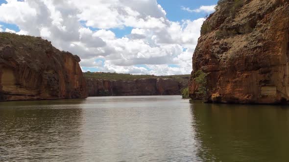 sailing smoothly on the waters of San Francisco river, among immense orange canyons, in Sergipe, Bra