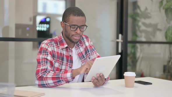 African Man Using Tablet While Sitting in Office