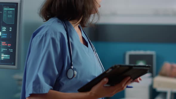 Female Nurse Holding Digital Tablet to Help Patient at Checkup Visit