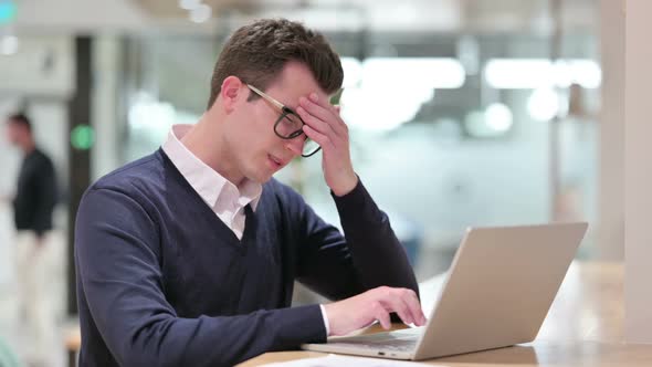 Stressed Young Businessman with Laptop Having Headache