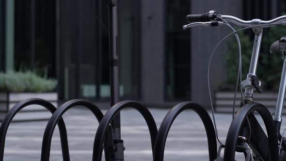 Closeup Electric Scooter Standing at Shared Parking Together with Black Bicycle