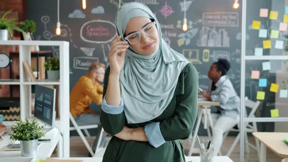 Portrait of Elegant Muslim Business Lady Taking Off Glasses Smiling Looking at Camera in Workplace