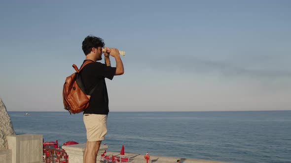 Young Boy Looks at the Sea on the Horizon with a Sheet Like a Spyglass