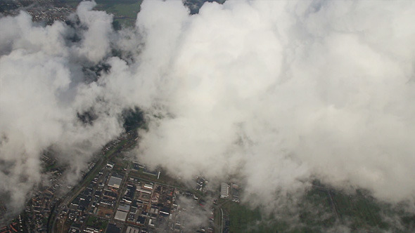 Airplane Flying over City and Clouds alt