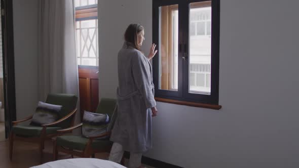 Woman looking out of the window at home