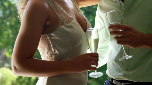 Couple looking face to face and holding champagne flutes in restaurant