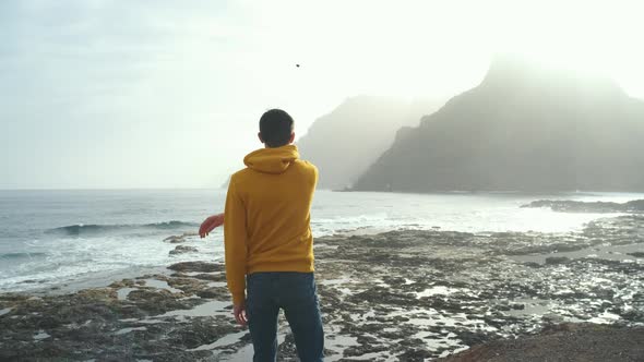 Tourist Man in Yellow Sweatshirt Walks on Volcanic Beach in North of Canary Island Tenerife