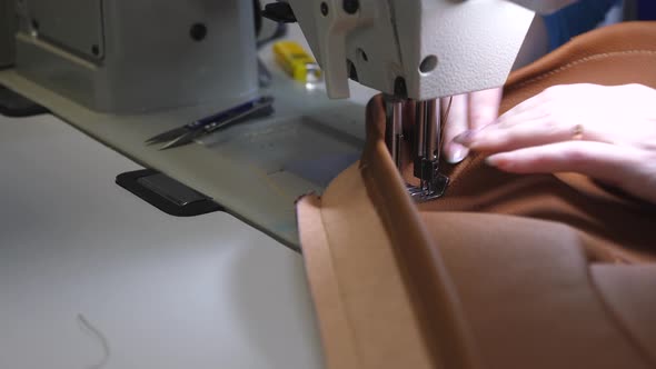 Tailor Sews Brown Leather in a Sewing Workshop