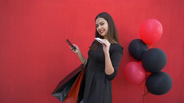 Online Shopping, Happy Smiling Girl Makes Purchases on Internet Using Mobile Phone and Plastic Card