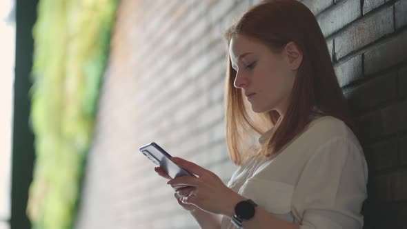 Beautiful Young Business Woman Using Phone in Office